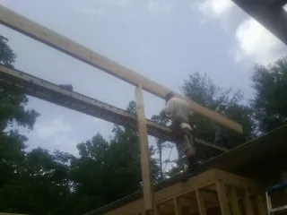 Carpenter setting a ridge beam over a new addition frame — Ice Dam Removal by Roofing Brothers in Carpinteria
